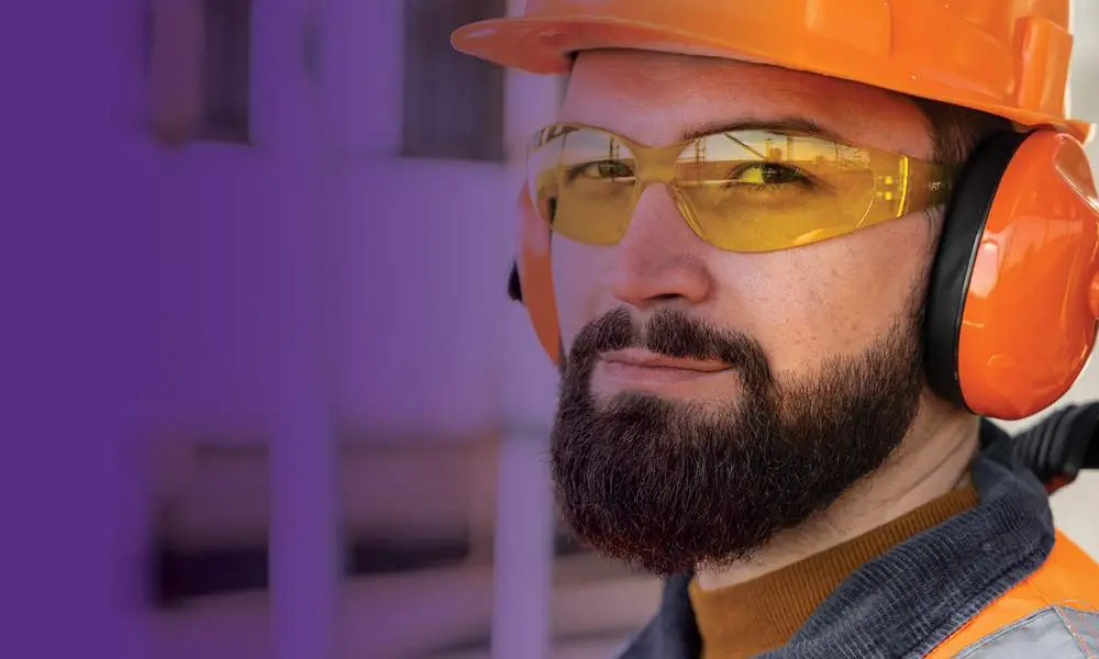 Worker in hard head with hearing and eye protection.